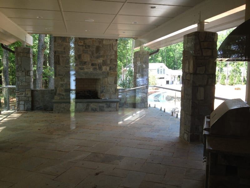 A large patio with a fireplace and a grill