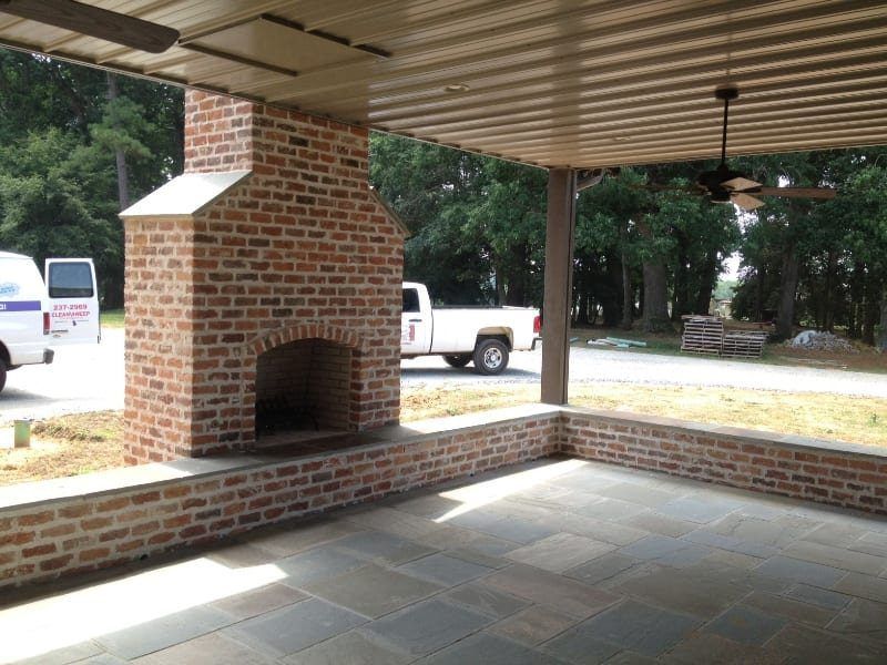 A white truck is parked in front of a brick fireplace