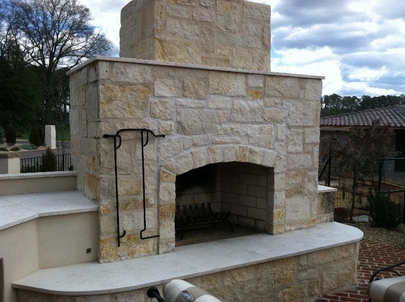 A large stone fireplace with a chimney on top of it