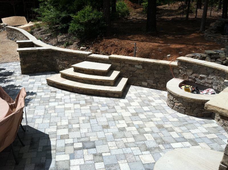 A stone patio with stairs and a fire pit