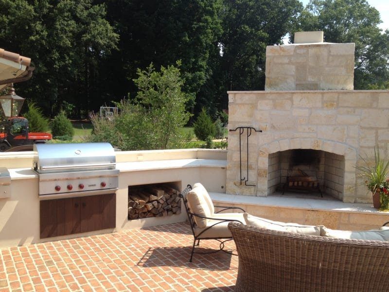 A patio with a fireplace and a grill