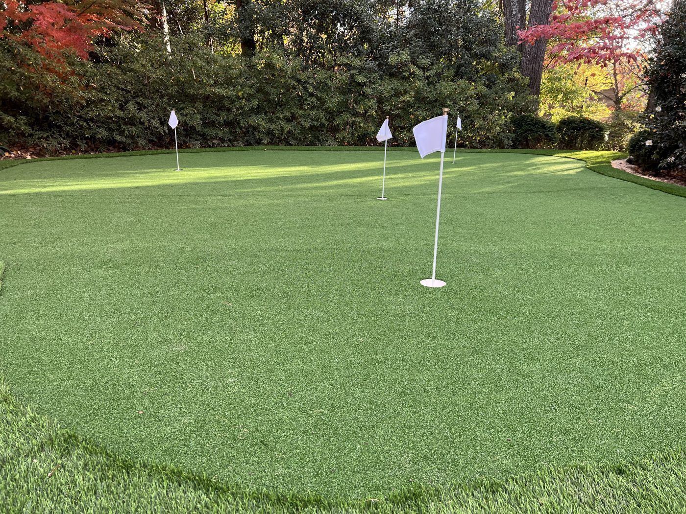A golf course with a white flag on the green