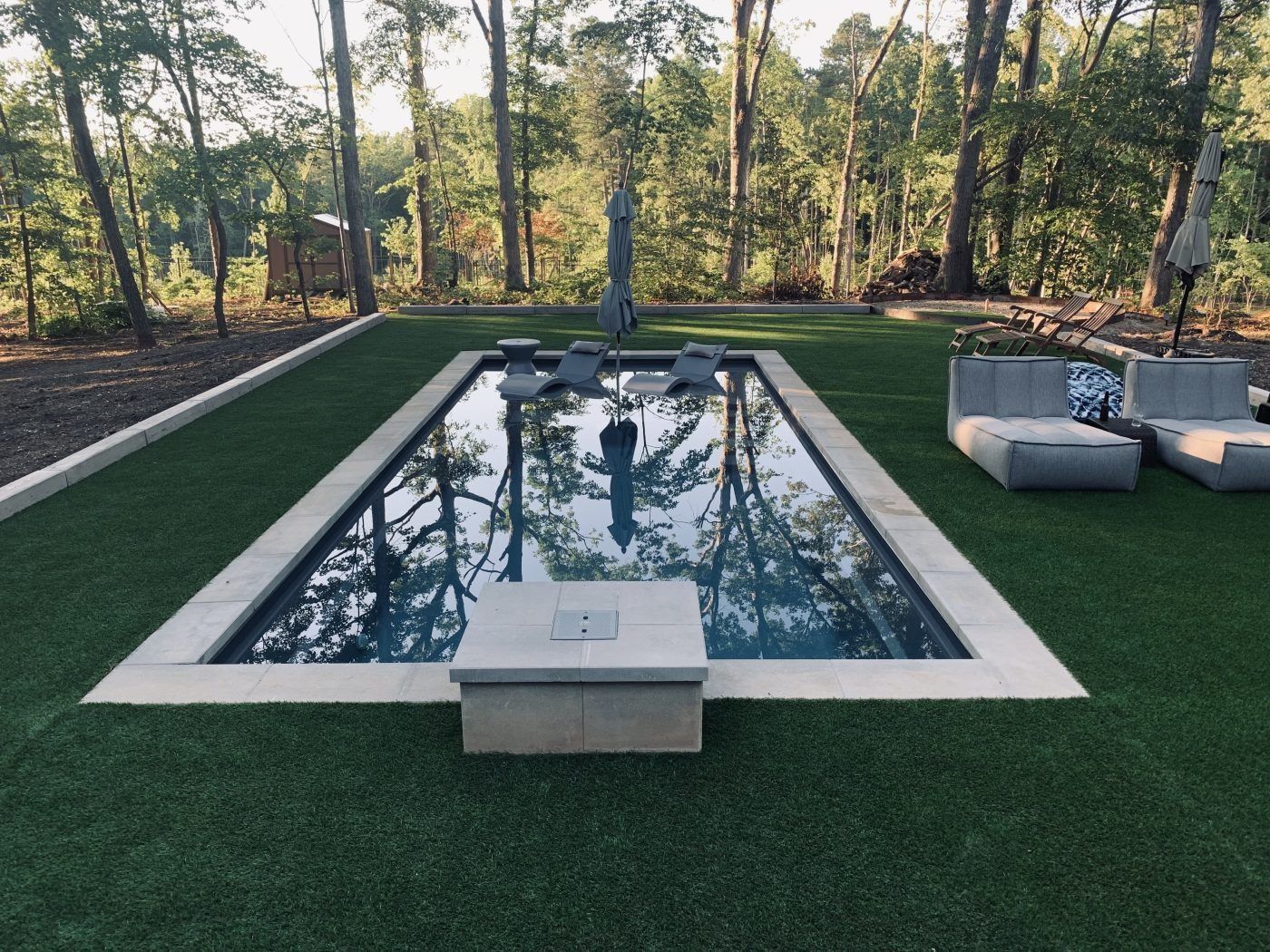 A large swimming pool surrounded by grass and trees