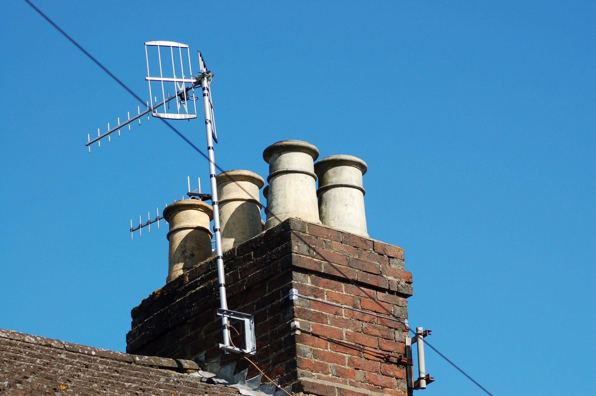 A brick chimney with an antenna on top of it