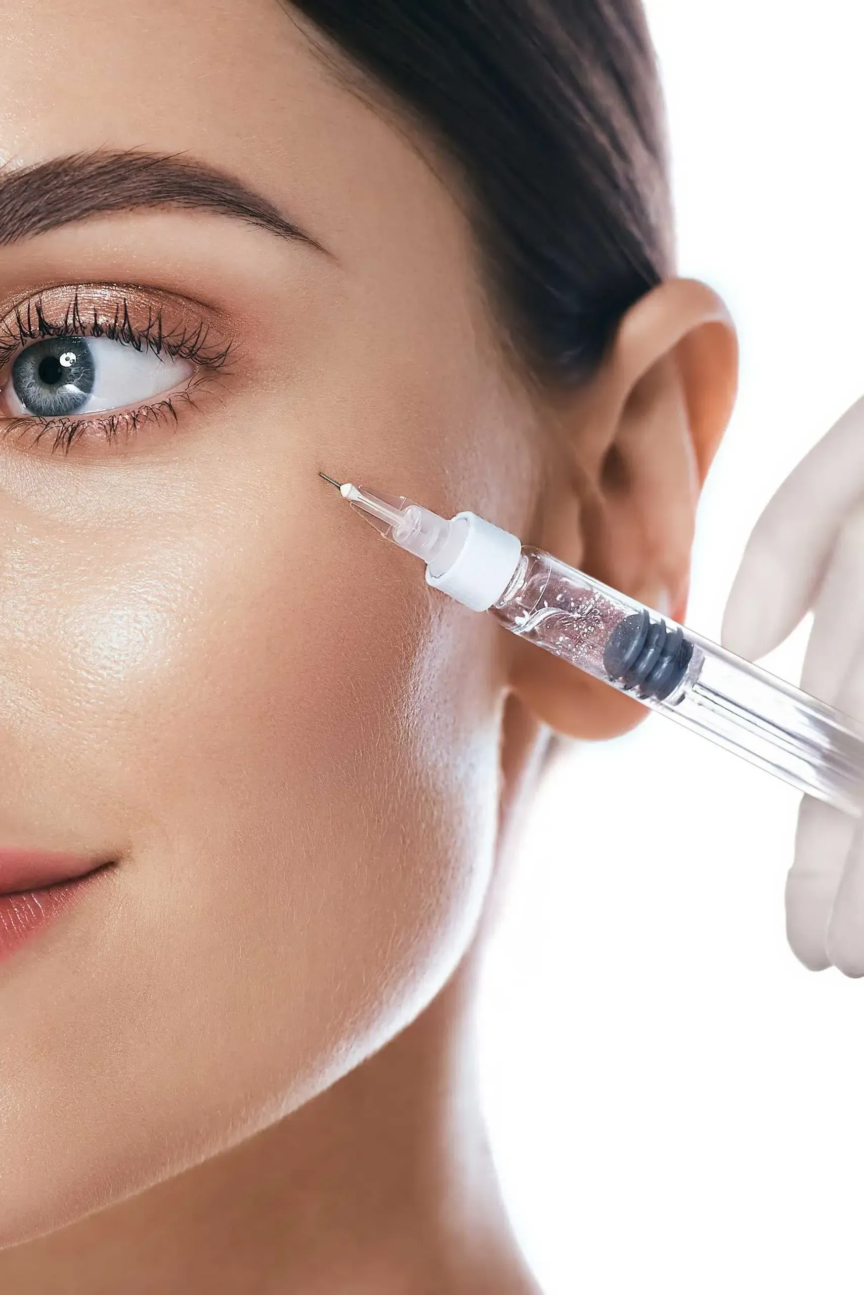 Eine Frau bekommt eine Botox-Injektion ins Auge.