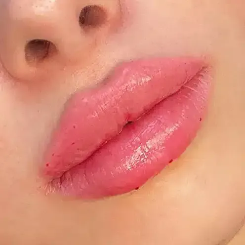 Eine Nahaufnahme der Lippen einer Frau mit rosa Lippenstift.