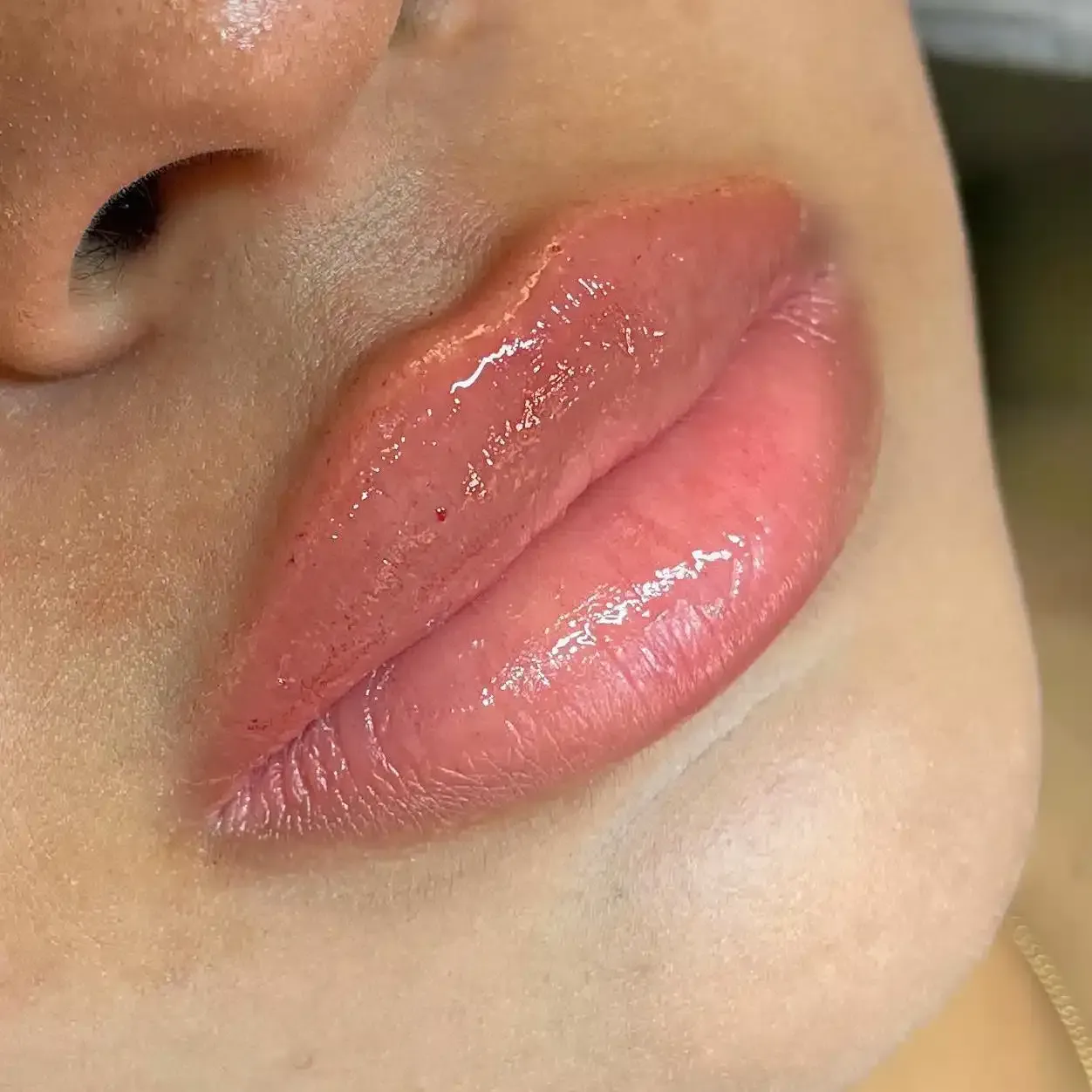 Eine Nahaufnahme der Lippen einer Frau mit rosa Lippenstift.