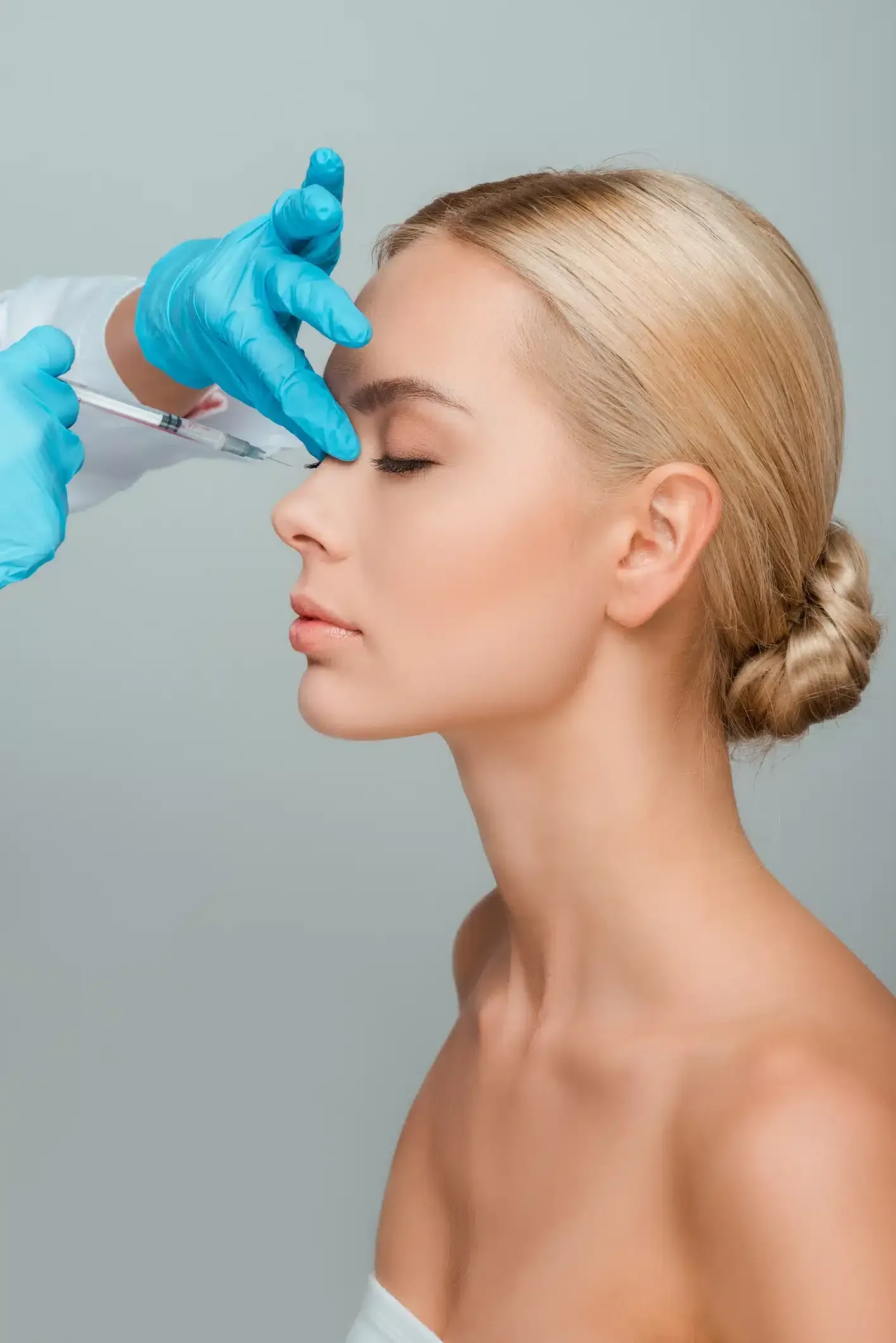 Eine Frau bekommt eine Botox-Injektion in die Stirn.