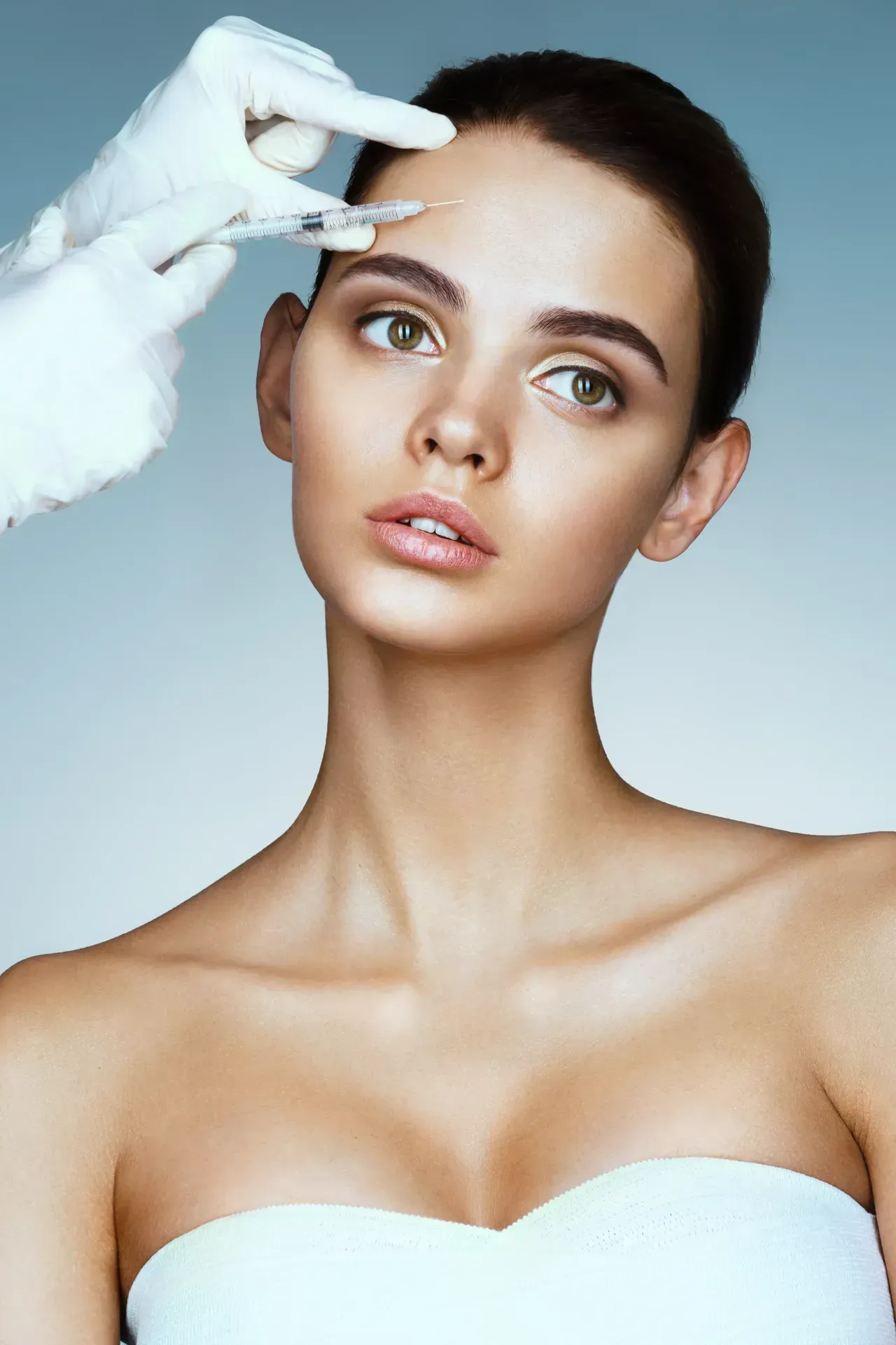 Eine Frau bekommt eine Botox-Injektion in die Stirn.
