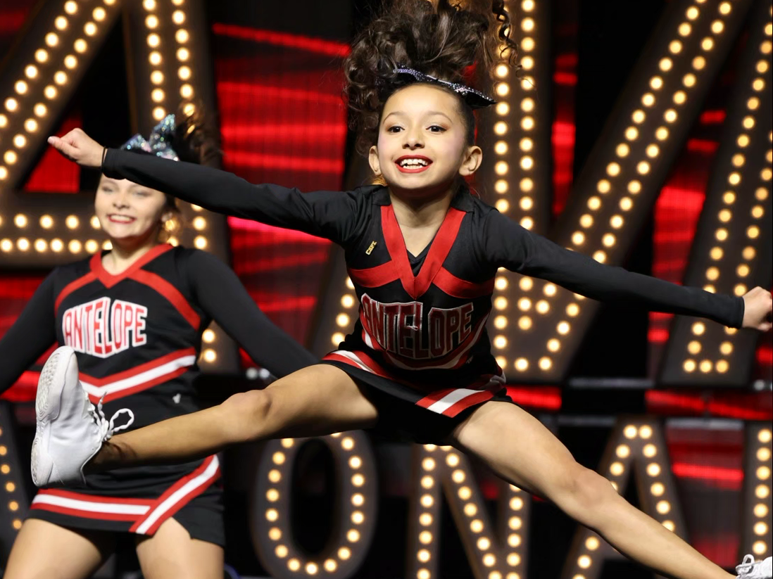 Red, white, and blue pom-poms held high by cheerleaders during a performance.