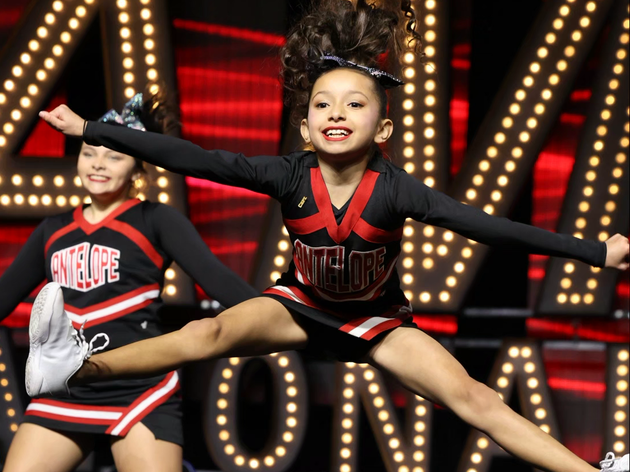 Red, white, and blue pom-poms held high by cheerleaders during a performance.