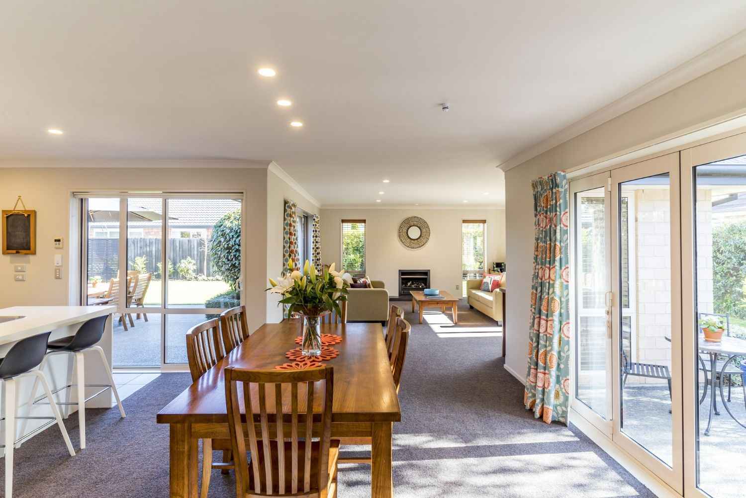 A dining room table and chairs in a house with a lot of windows.