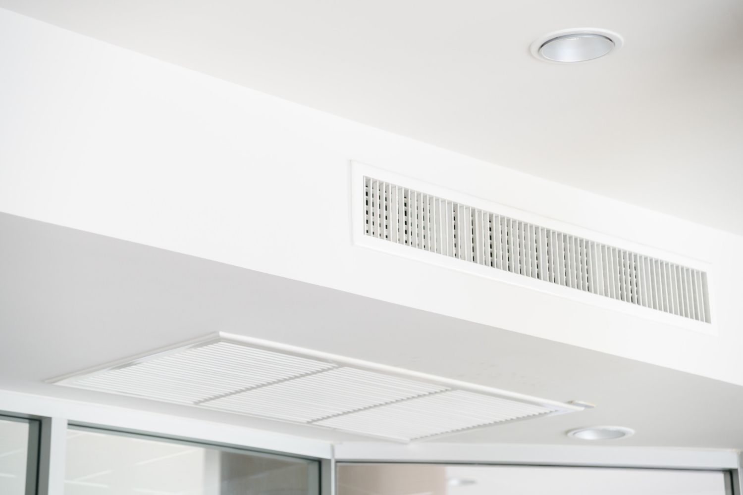 A close up of a ceiling air vent in a room.