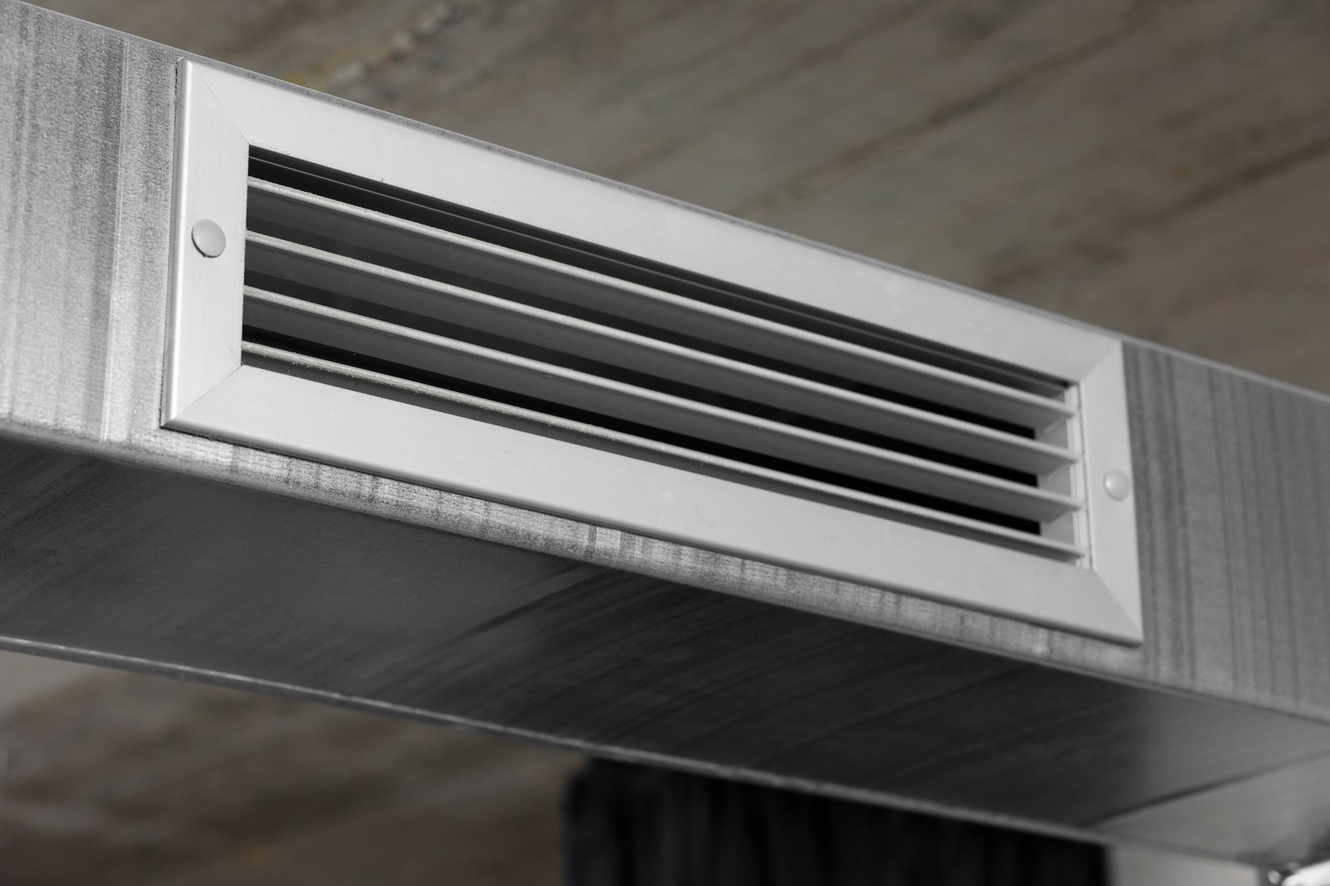 A close up of a white air vent on a ceiling