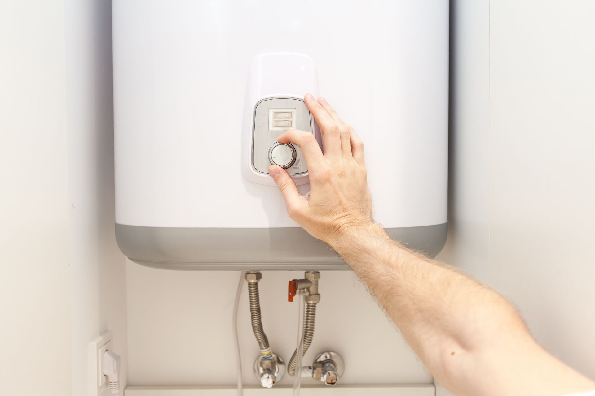 a person is adjusting the temperature of a water heater .