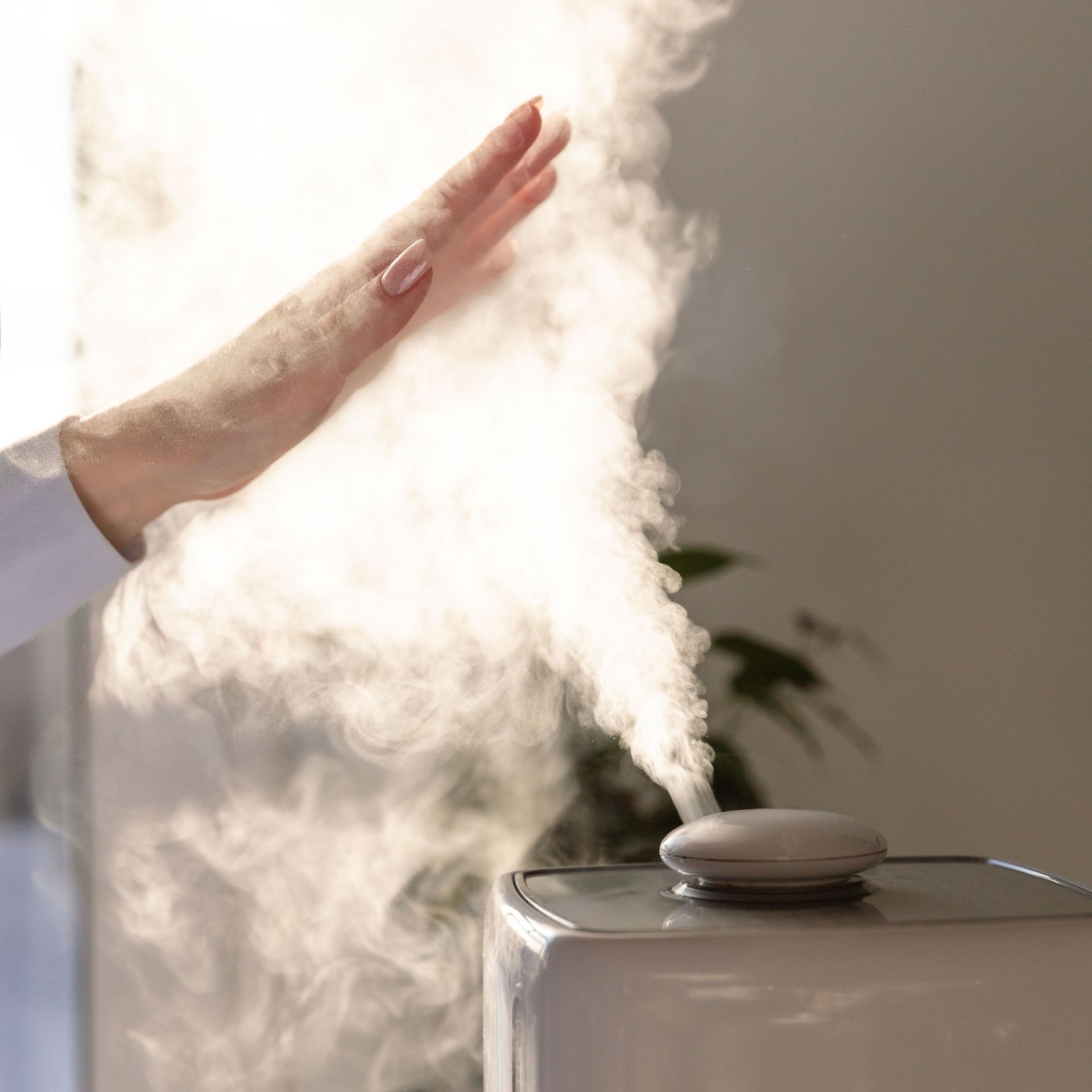 a person is touching a humidifier with their hand .