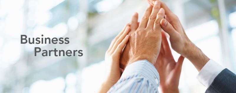 A group of business partners are putting their hands together.