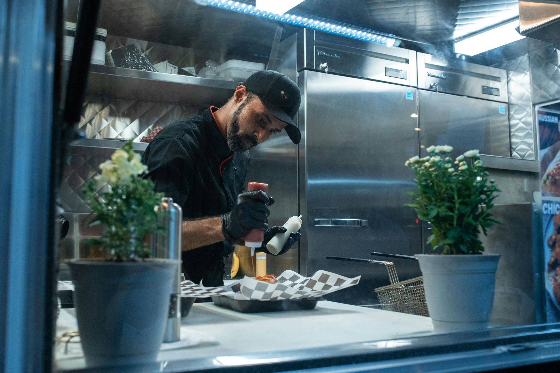 A man is preparing food in a kitchen in a food truck.
