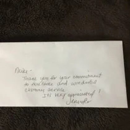 A handwritten note on a white envelope thanking 