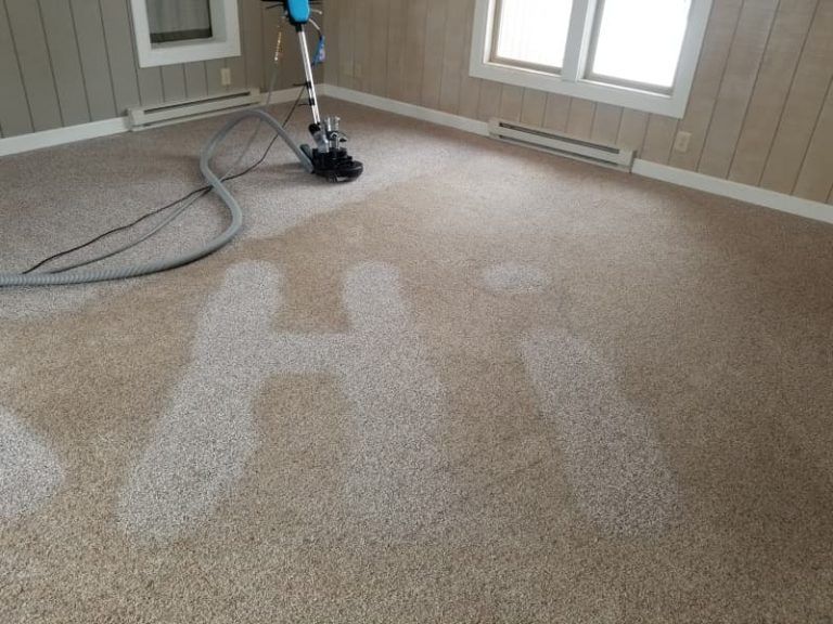 A vacuum cleaner is cleaning a carpet in a room