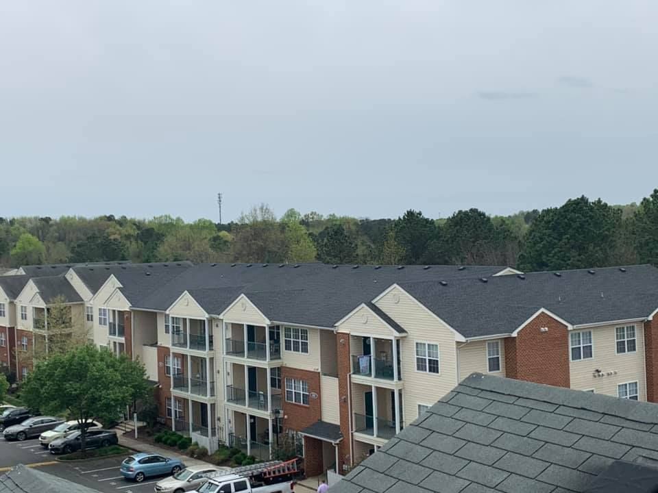 A large apartment building with a lot of cars parked in front of it