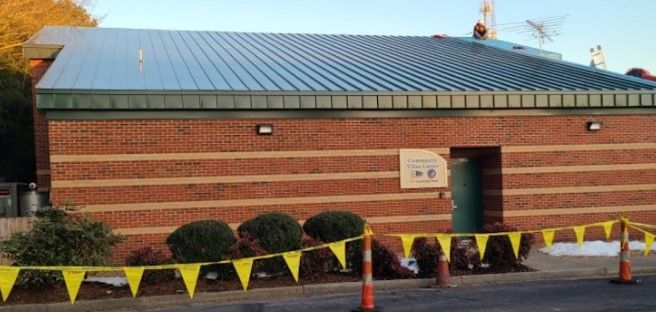 A brick building with a metal roof is being built.
