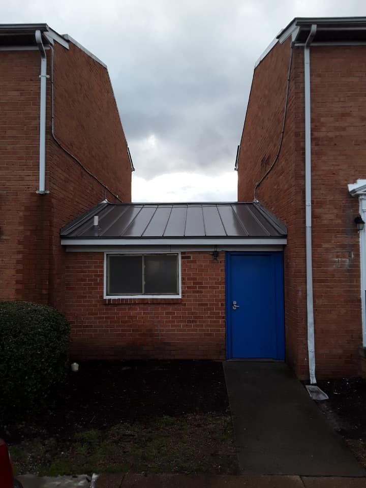 A brick building with a blue door and a window