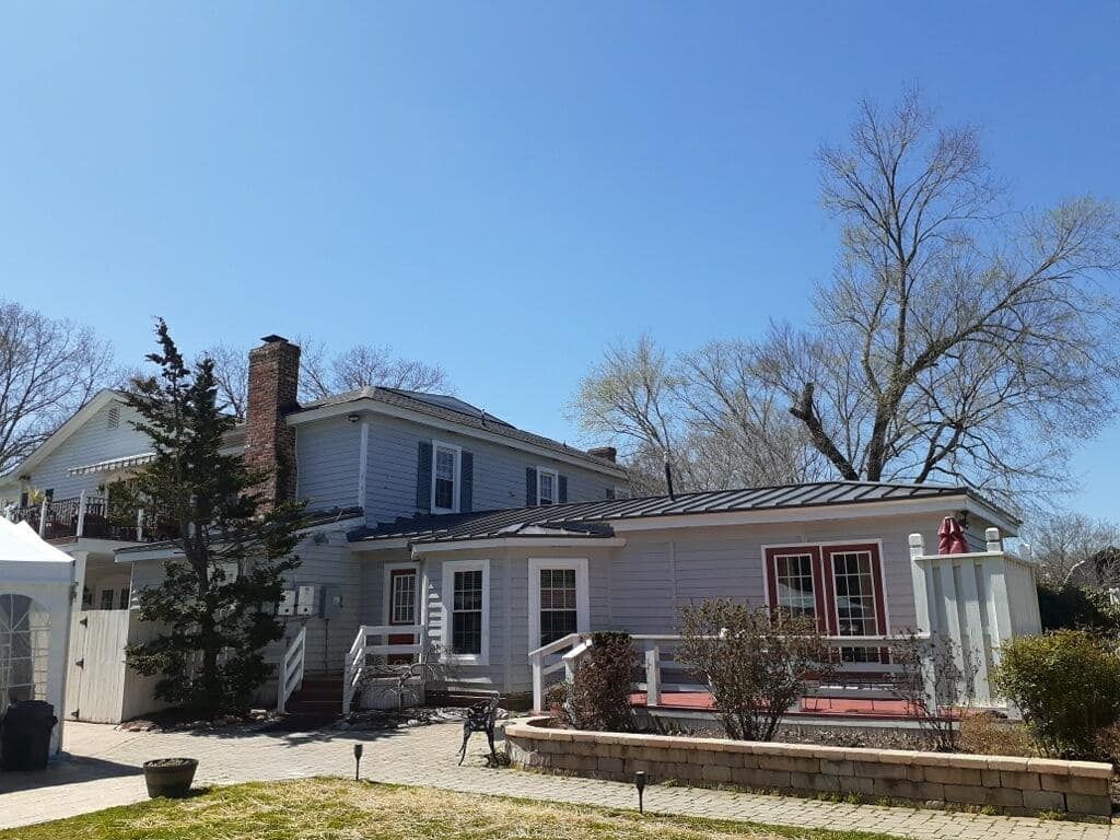 A large white house with a blue sky in the background.