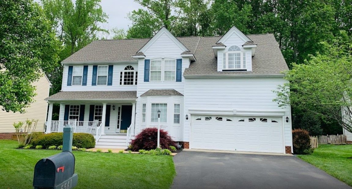 A large white house with a mailbox in front of it.
