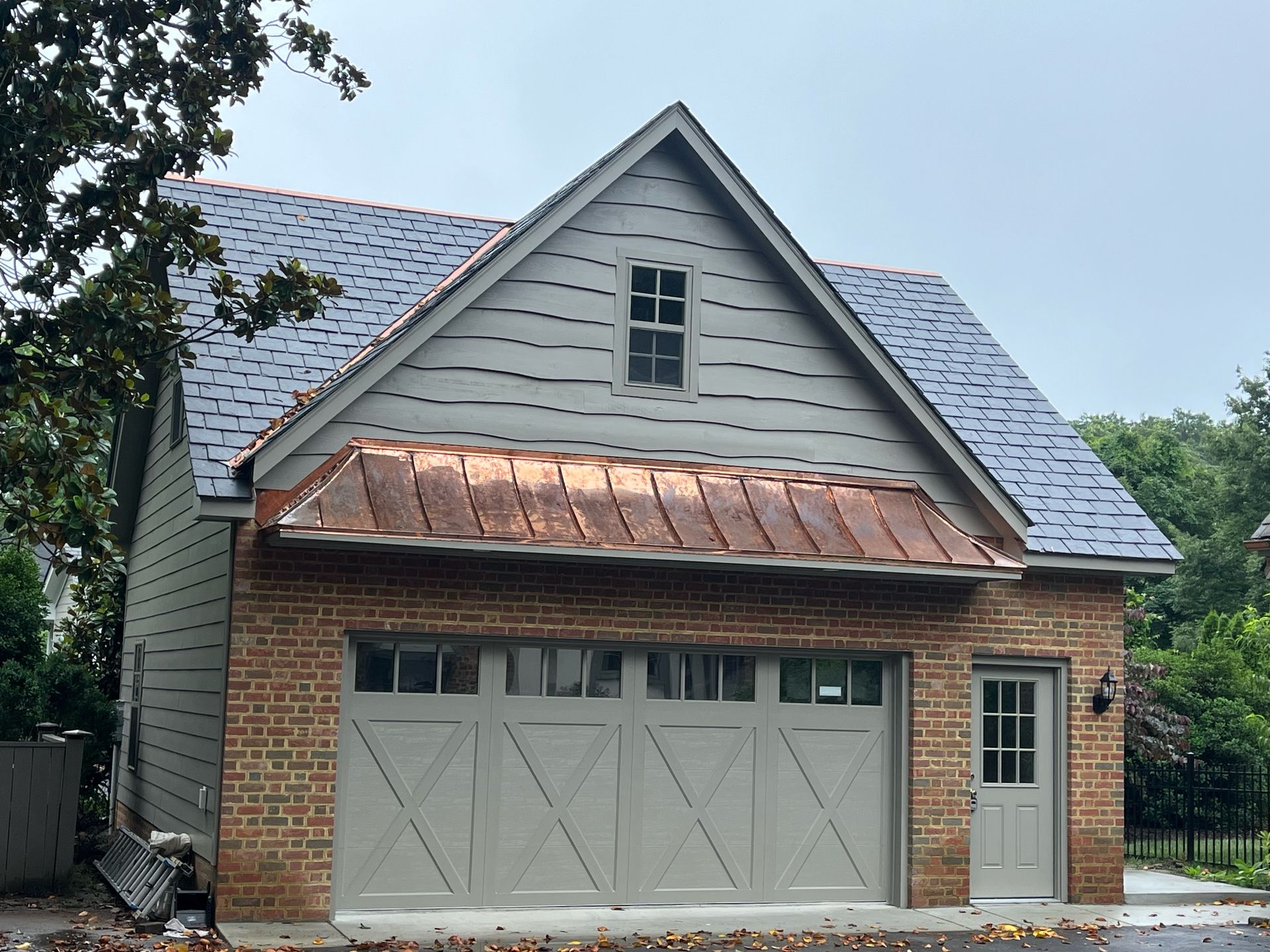 A large brick garage with a copper roof