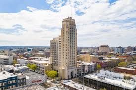 An aerial view of a city with a tall building in the middle of it.