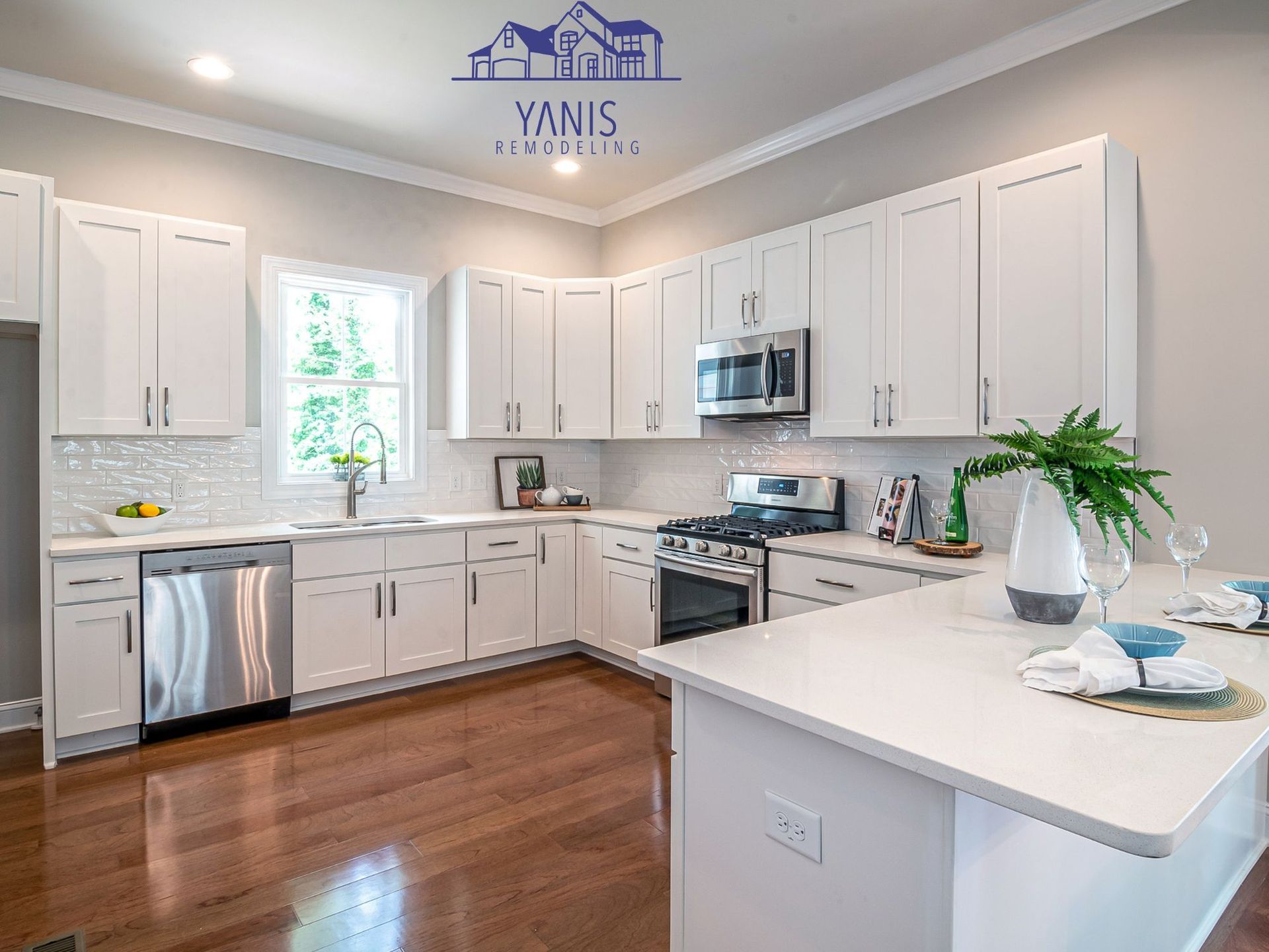A kitchen with white cabinets , stainless steel appliances , and hardwood floors.