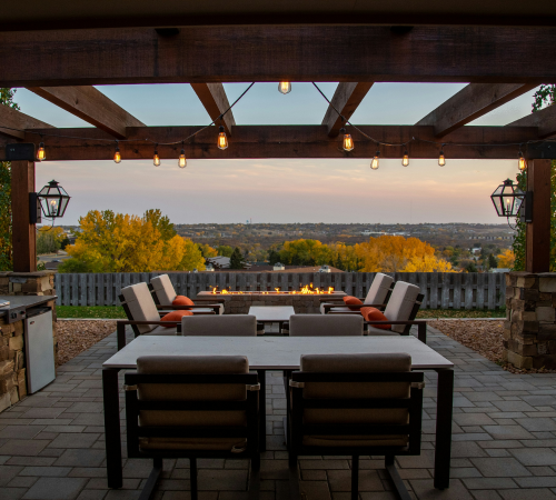 A patio with a table and chairs and a fire pit