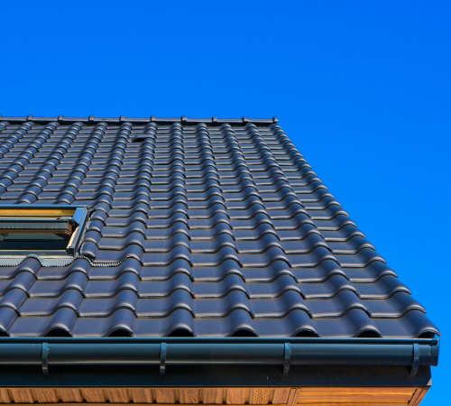 Looking up at a roof with a blue sky in the background.