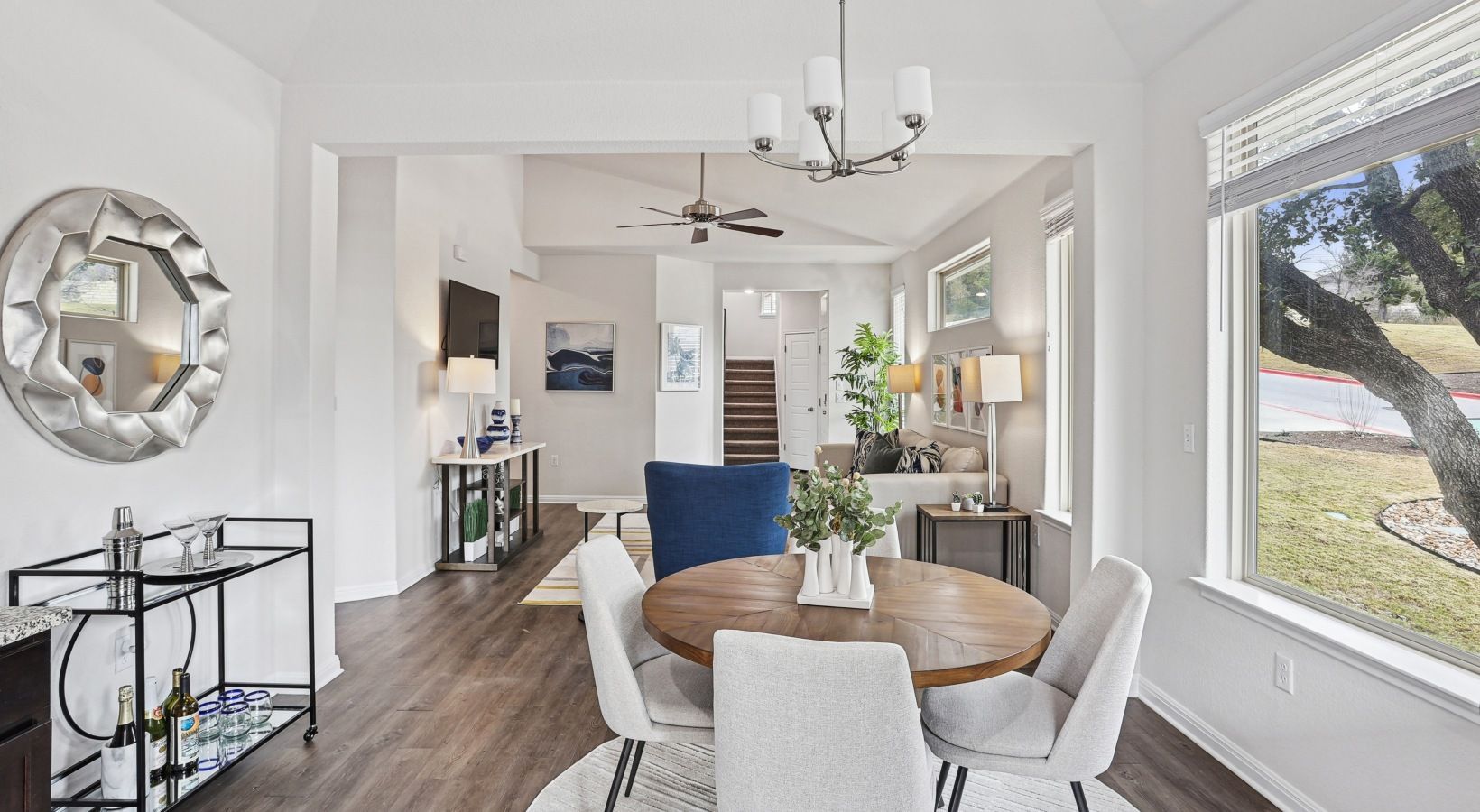 Open-concept living and dining area with large windows and modern furnishings.