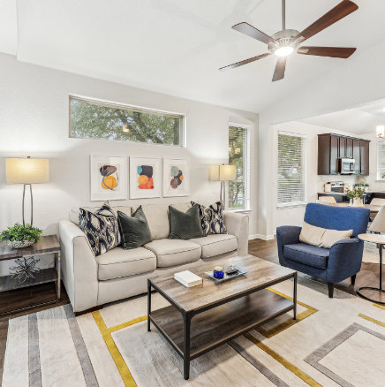 Living room with beige sofa, blue armchair, and modern art.