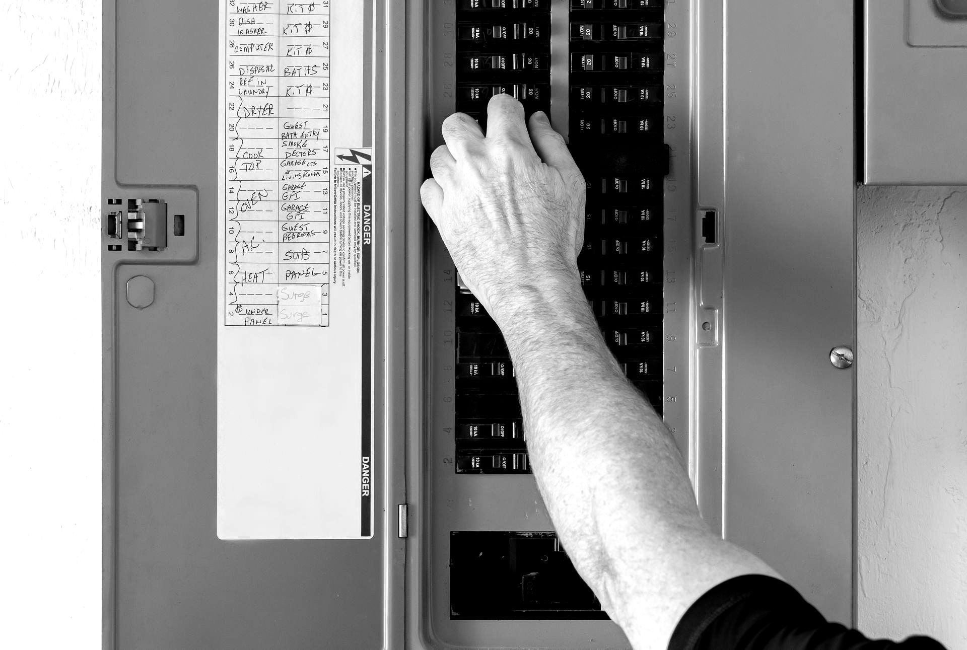 Une personne appuie sur un bouton d'un boîtier électrique.