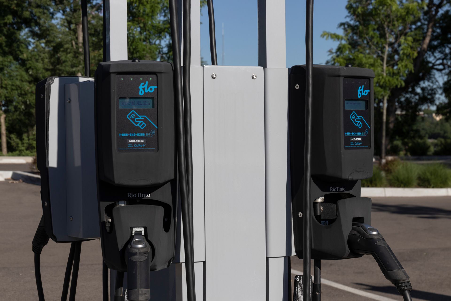 Une rangée de bornes de recharge pour véhicules électriques dans un parking.