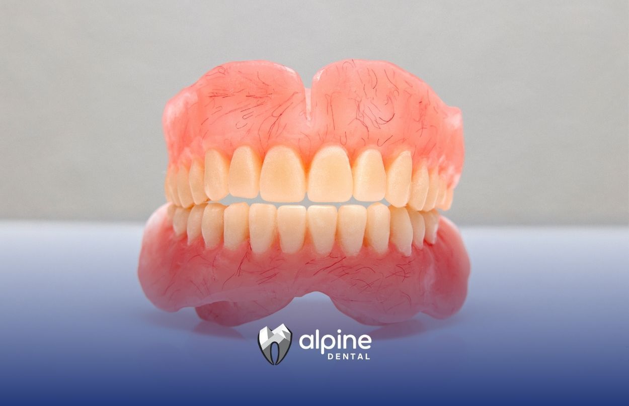 A close up of a denture on a white surface.