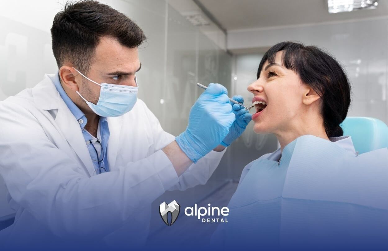 A dentist is examining a woman 's teeth in a dental office.