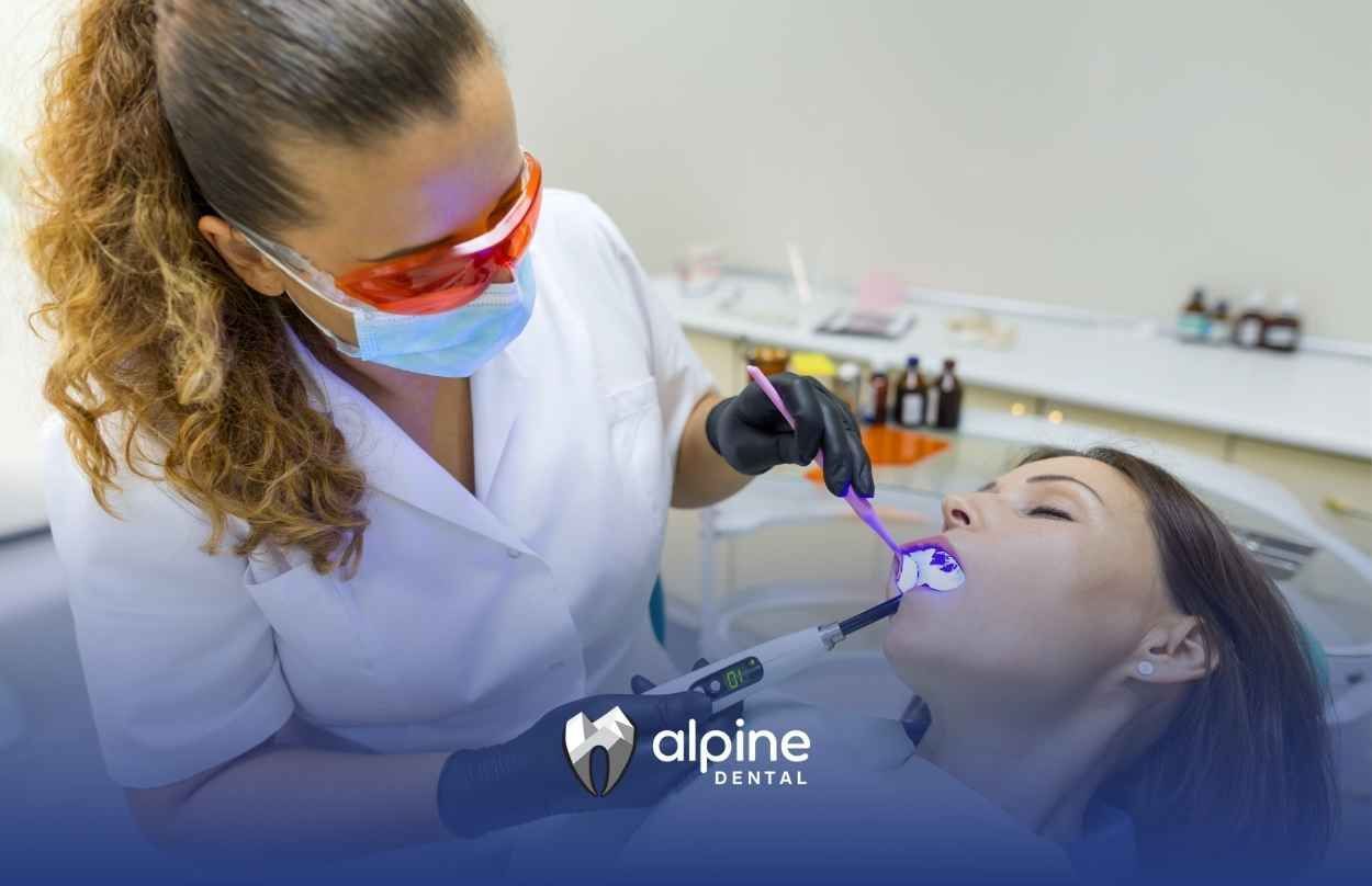 A woman is getting her teeth examined by a dentist in a dental office.