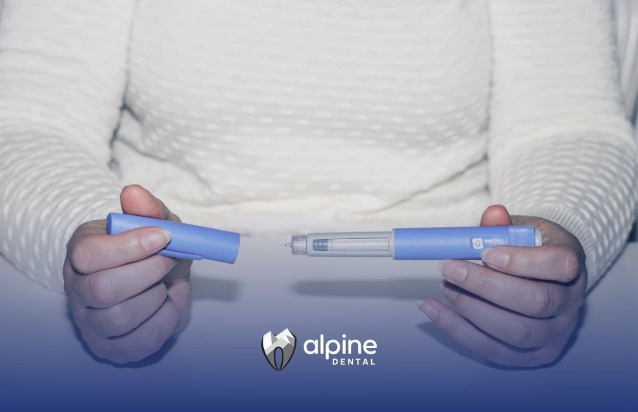Hands holding a blue dental syringe-like tool.