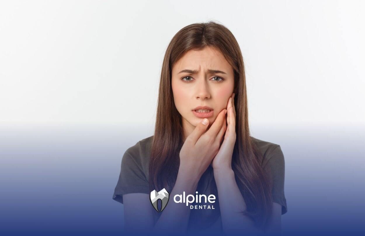 A woman is holding her face in pain because she has a toothache.