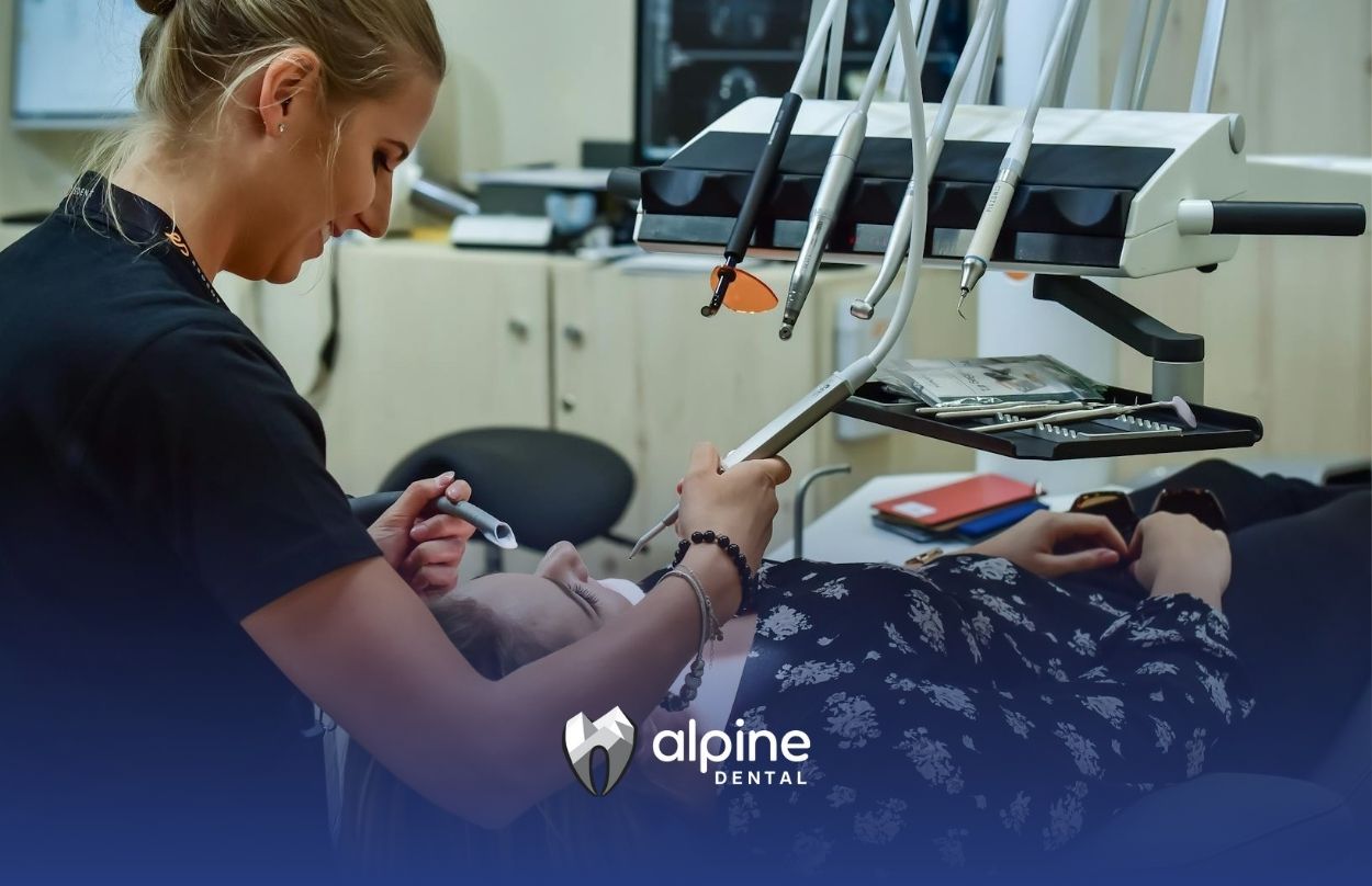 Female dentist performing a cleaning procedure on a patient at a dental clinic in Lakewood, NJ.