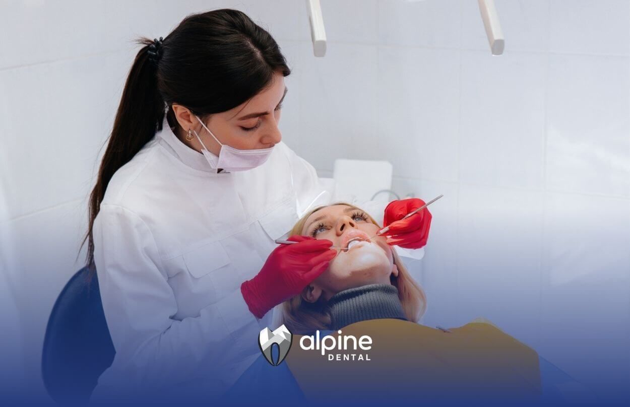 A woman is getting her teeth examined by a dentist.