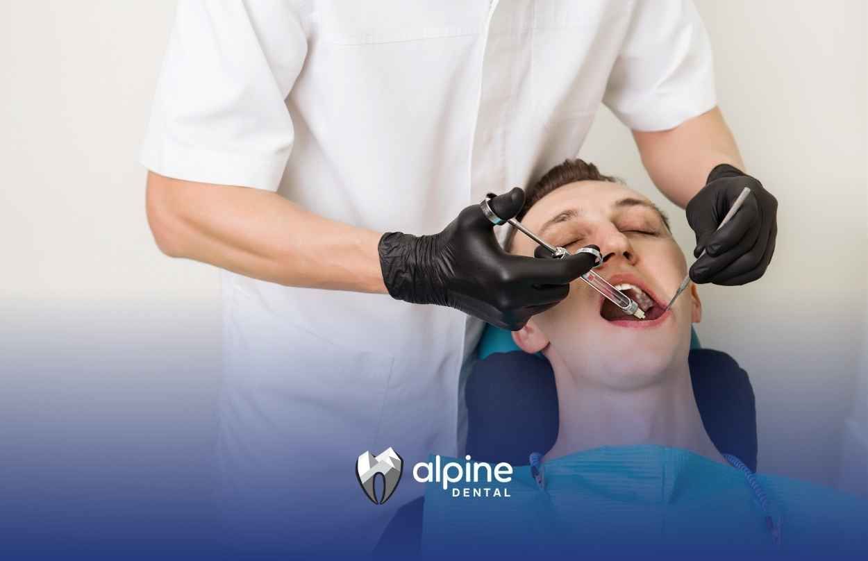 A man is getting his teeth examined by a dentist.