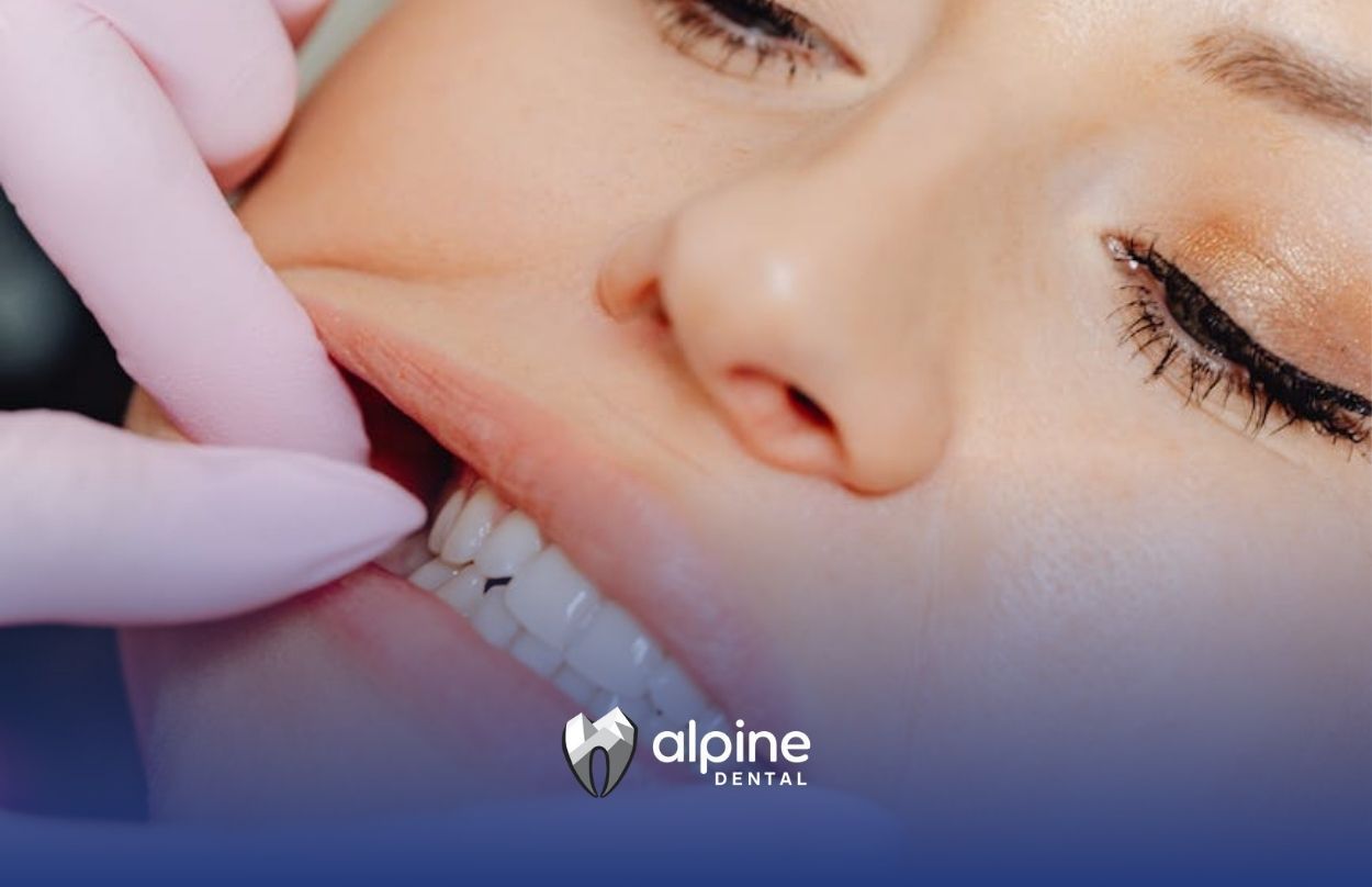 Dentist checking a woman’s teeth and swollen gums with gloved hands at a dental clinic in New Jersey