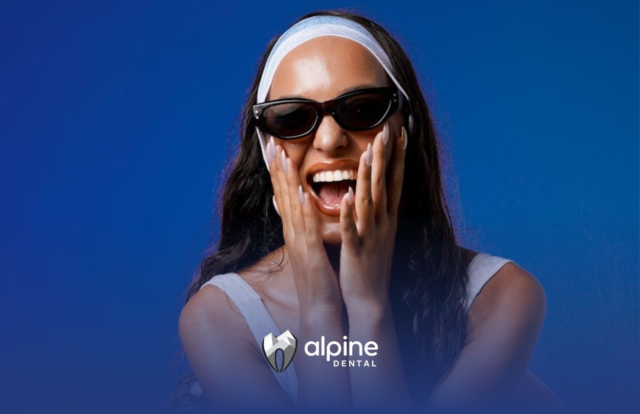 Woman in sunglasses and swim ring laughing joyfully at a dental clinic in Lakewood, New Jersey.