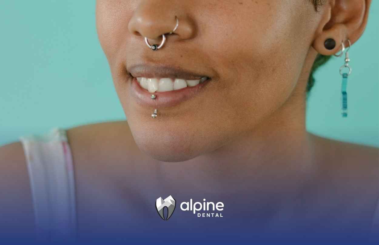 A close up of a woman's face with a nose ring and earrings.