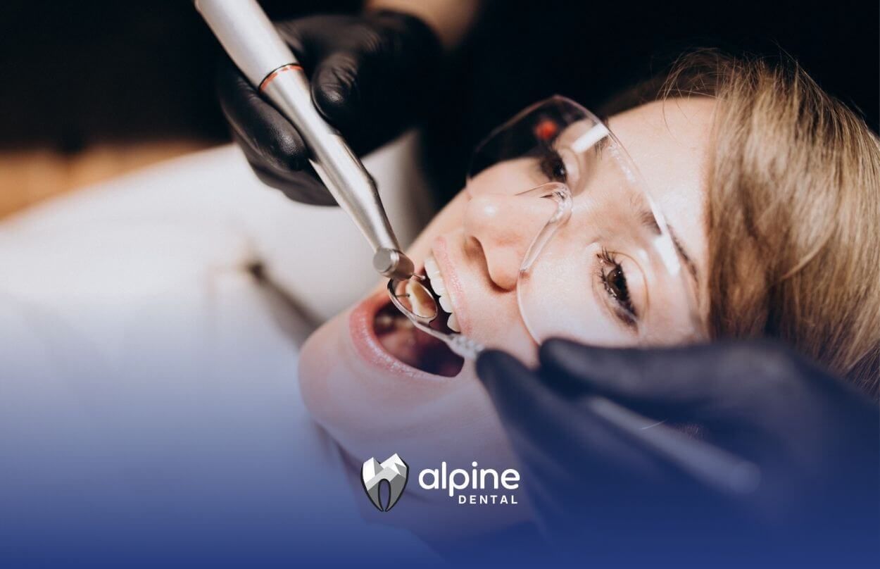 Close-up of a woman receiving dental treatment with tools.

